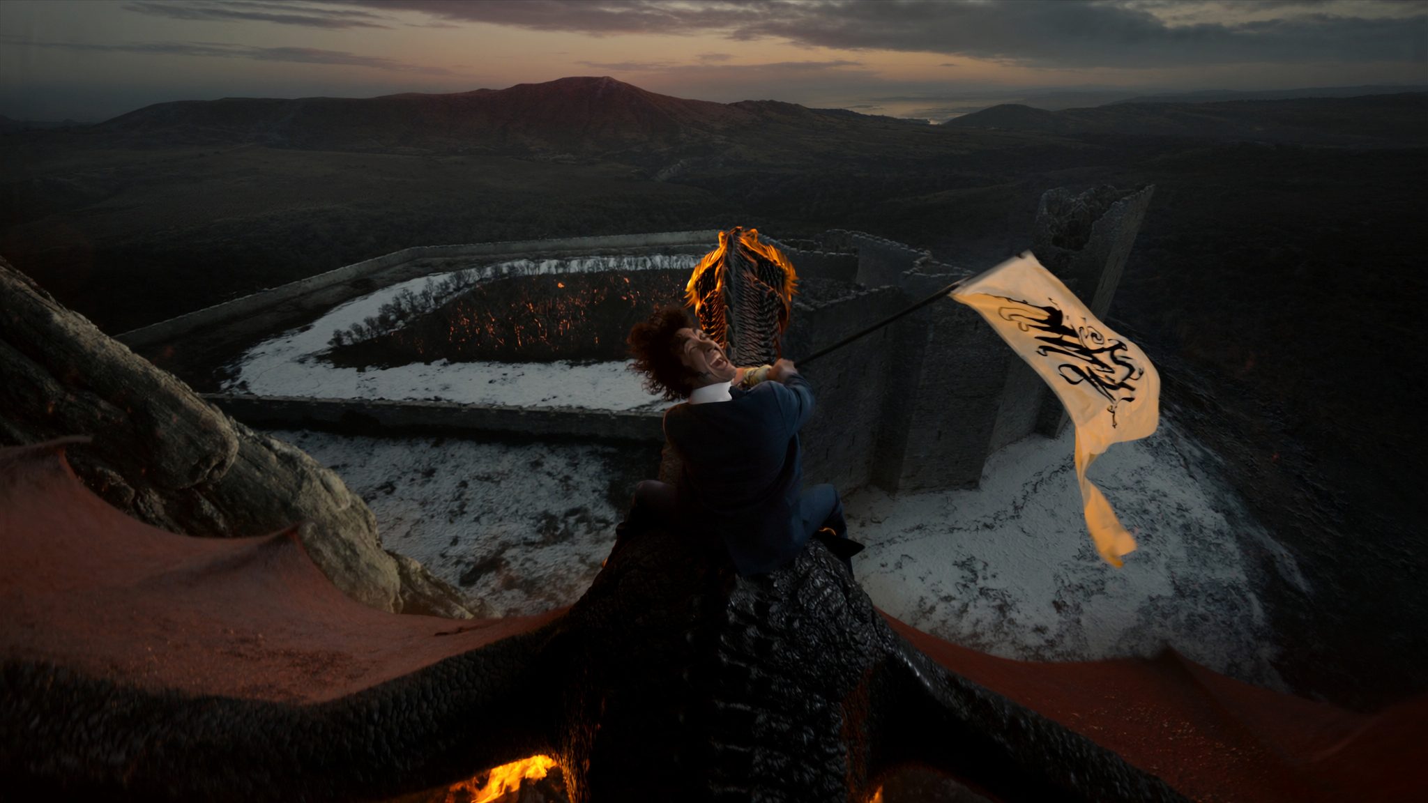 Aerial dragon scene with cream parchment banner streaming in the wind. Banner reads NUTS.